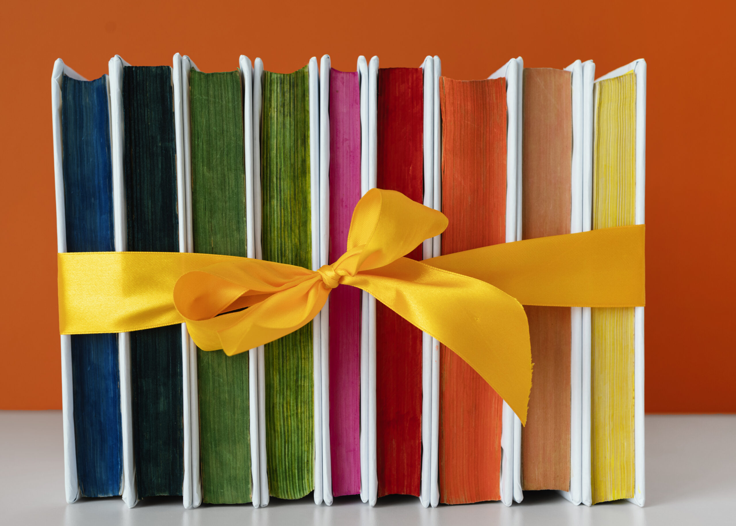 pila-de-libros-de-arco-iris-con-cinta-amarilla